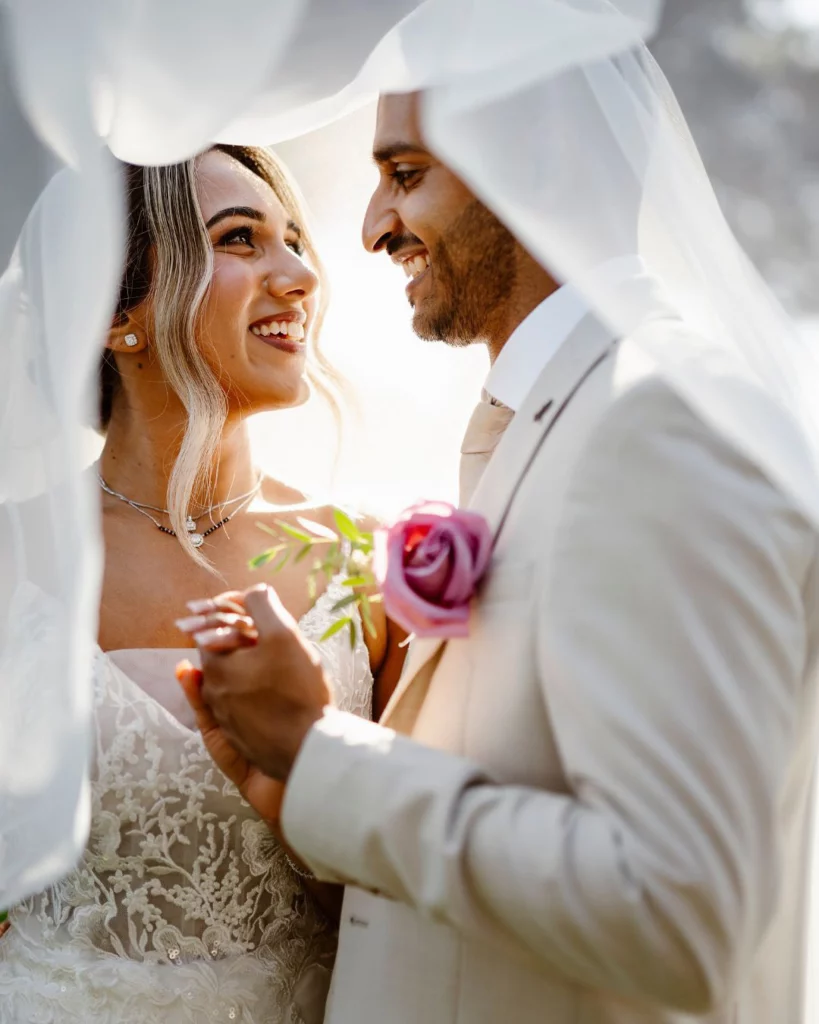 bride-and-groom-smiling-under-veil-romantic-portrait