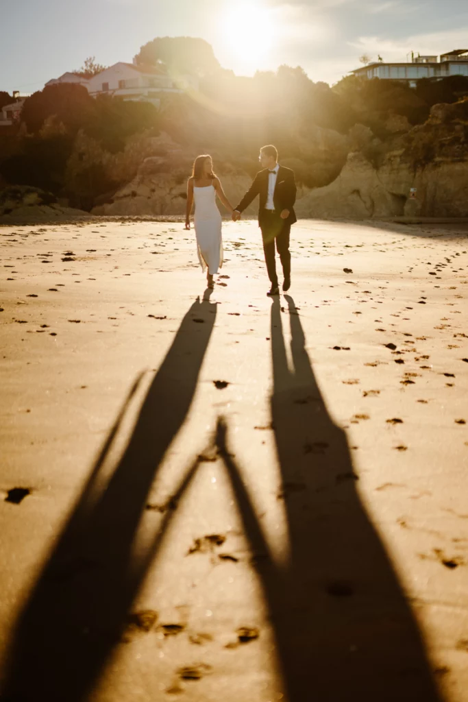 couple-walking-hand-in-hand-on-algarve-beach-sunset