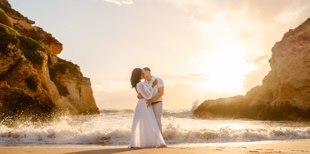 A couple kissing in front of small waves A couple kissing in front of small waves